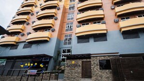 Un hotel de varios pisos con balcones y unidades de aire acondicionado.