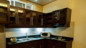 Una cocina con armarios de madera oscura, un microondas y un lavabo.