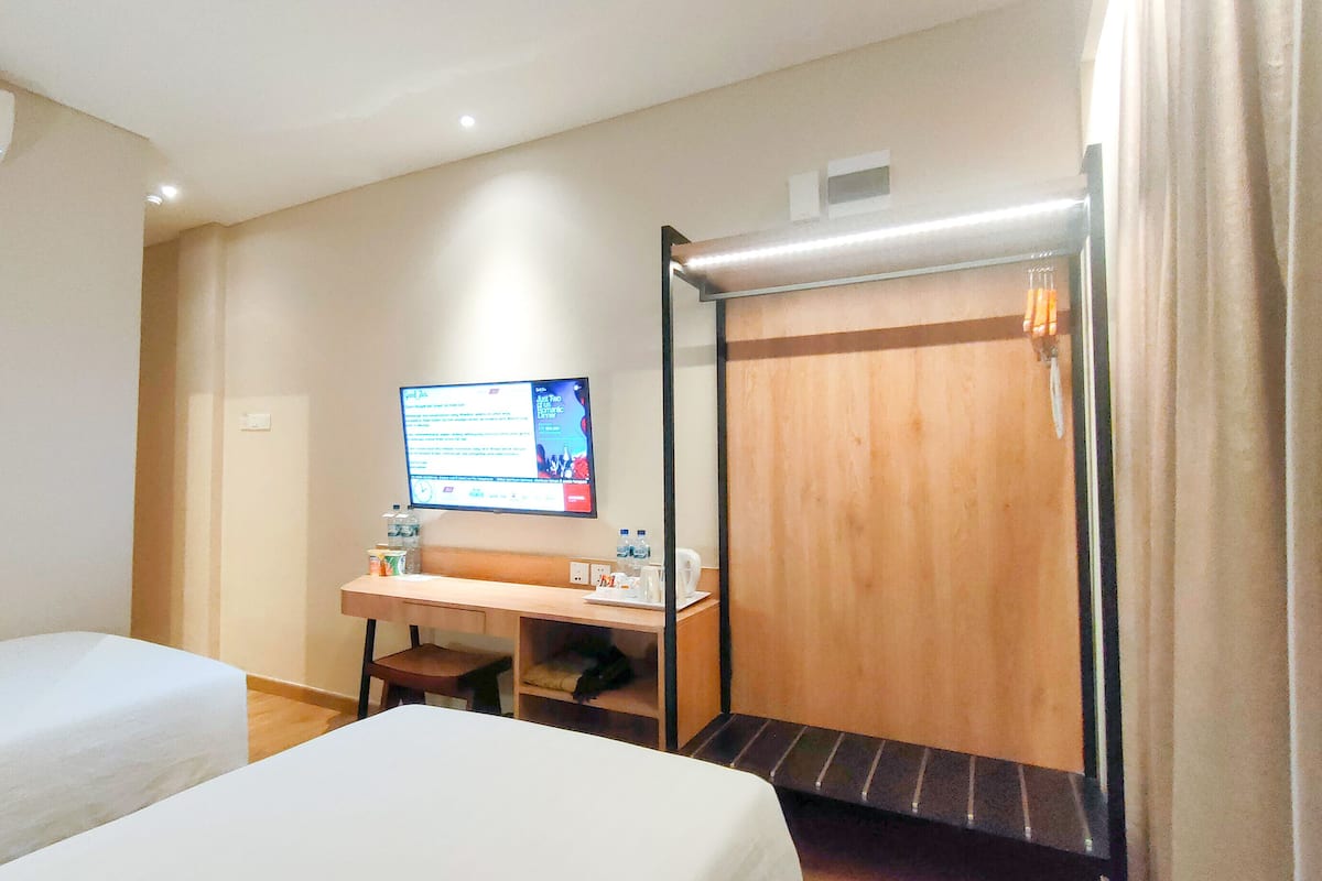 Ein Hotelzimmer mit Bett, Schreibtisch, Stuhl, Fernseher und Duschbereich.