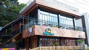 A modern building with a wooden facade, large windows, and a balcony. - White Cabin (Pyeongchang)