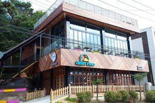 A modern building with a wooden facade, large windows, and a balcony.