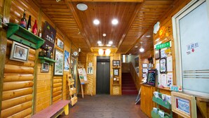 A wooden interior with benches, a staircase, and various informational displays. - White Cabin (Pyeongchang)
