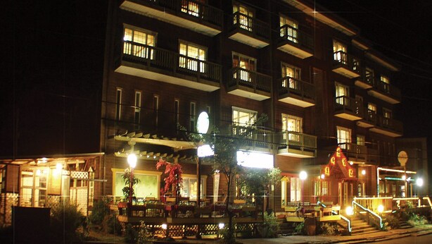 A multi-story hotel with balconies and a well-lit entrance. - White Cabin (Pyeongchang)