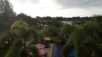 Un resort con zona de piscina, sillas de descanso y vistas a un lago.