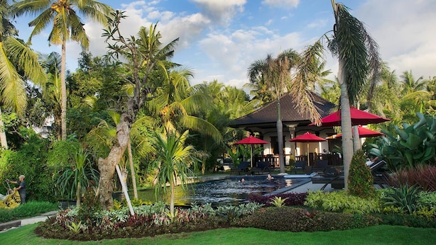 Un resort con piscina, palmeras y un pabellón.