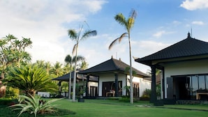 Un moderno resort con varias edificaciones, abundante vegetación y palmeras.