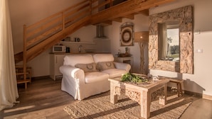 A cozy living room with a white sofa, wooden coffee table, and a rustic staircase. - Monte do Cardal (Aljezur)