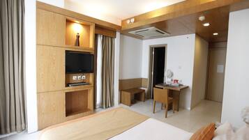 Une chambre d’hôtel comprenant un lit, un bureau, une chaise, une télévision et une salle de bain.