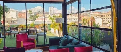 Zona pranzo moderna con vista sulla città attraverso ampie finestre.