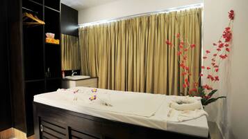 A hotel room with a bed, a vanity with a mirror, a sink, and a wardrobe.
