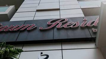 Un edificio con un letrero que dice "Resid" y otro letrero con texto en un alfabeto no latino.