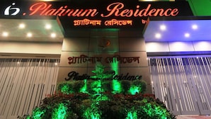 A building with a sign reading "Platinum Residence" and a logo.