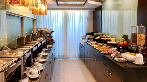 A buffet setup with various food stations, including fruits, vegetables, and prepared dishes.