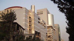 A modern building with a curved facade and a cylindrical structure on the left. - Platinum Grand (Dhaka)