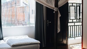 A room with two beds, a mosquito net, and a view of the outside. - Suite Home Boutique Hotel (Phnom Penh)