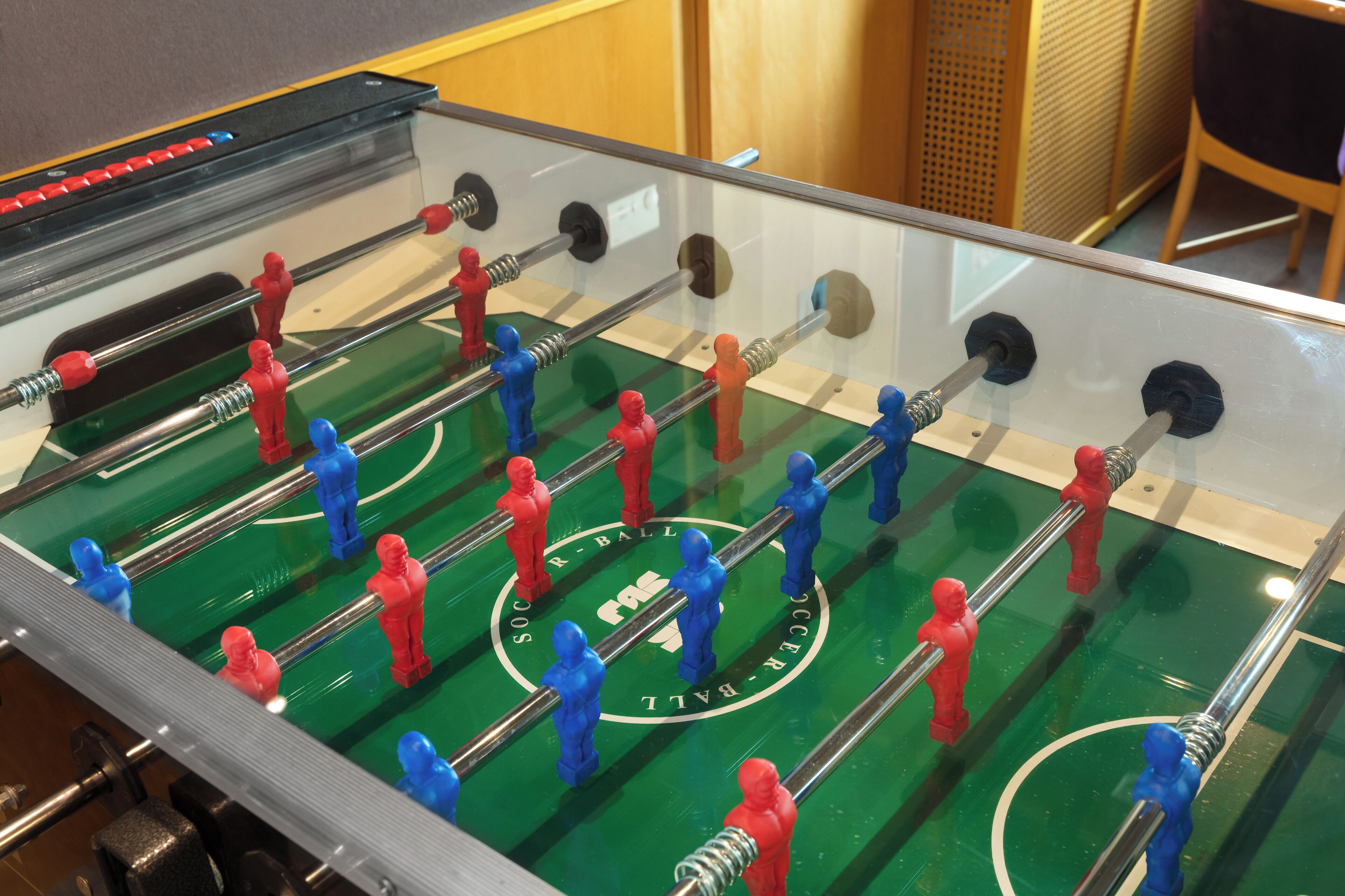 Una mesa de fútbolín con figuras rojas y azules.