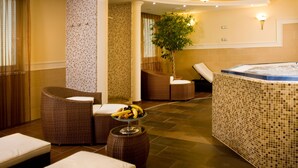 A spa area with wicker furniture, a hot tub, and a fruit bowl. - Hotel Kálvária (Gyor)