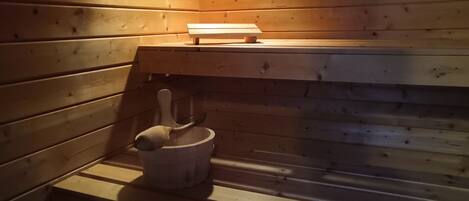 Un sauna avec des murs et des bancs en bois.