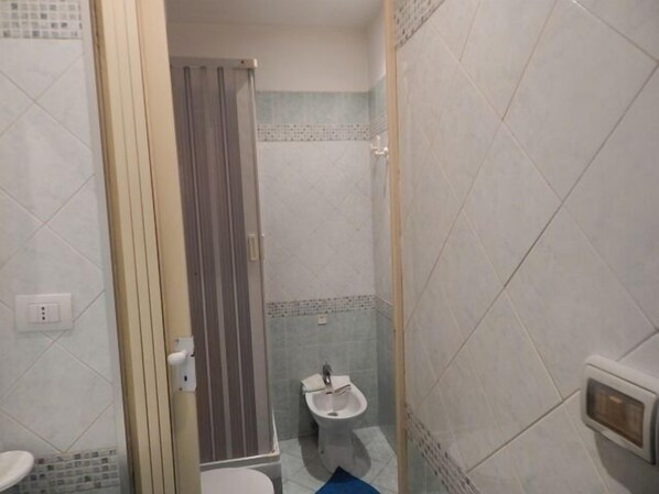 A narrow bathroom with a toilet, bidet, and shower area. - Rooms 20 Settembre (Catania)