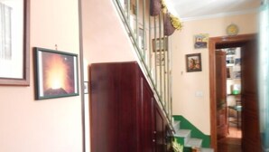 A staircase with a wooden handrail and a green carpeted landing. - Rooms 20 Settembre (Catania)