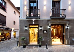 A hotel entrance with a double door, a sign indicating 'Casa Palacete 1822', and a small tree in front. - Casa Palacete 1822 (Granada)