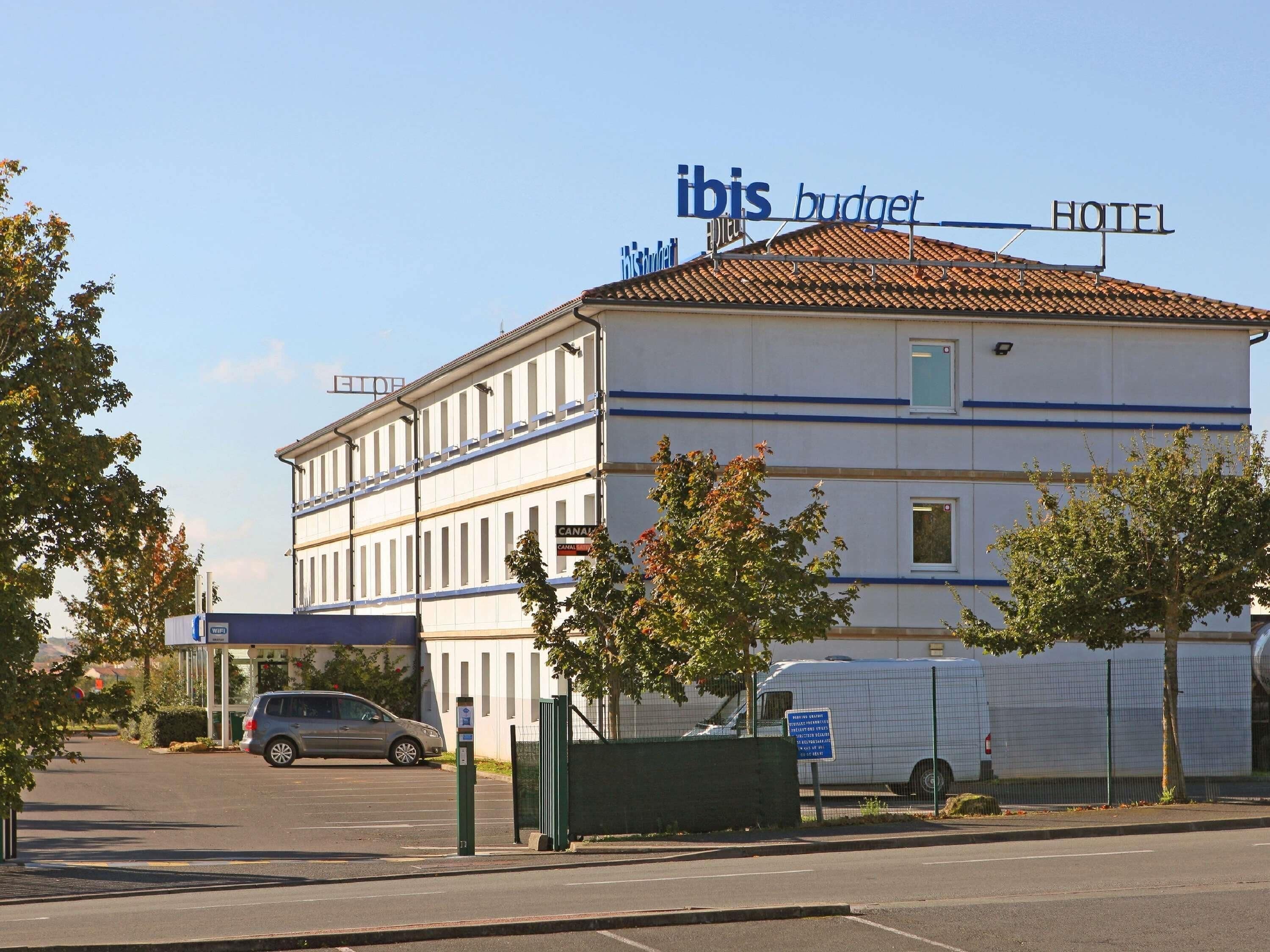 A two-story building with a sign for 'ibis budget HOTEL' and a 'CANAL' sign on the ground floor.
