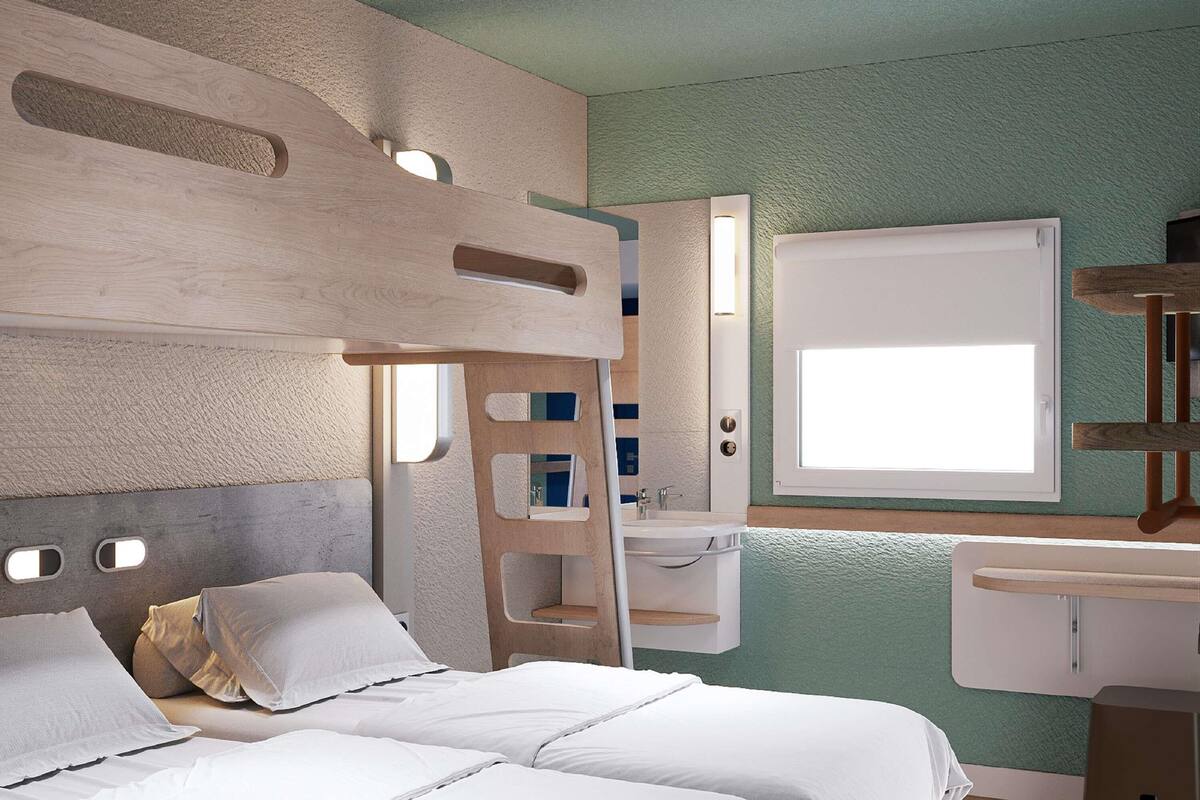 Una cama litera con escalera, una mesita de noche, una ventana y un espejo.