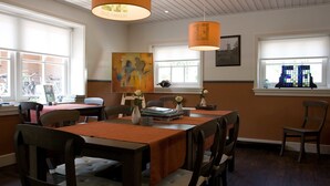 A dining area with a wooden table, chairs, and pendant lights. - B&B Erve Fakkert (Rossum)