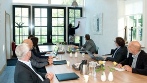 A conference room with a large table, laptops, and a whiteboard. - B&B Erve Fakkert (Rossum)