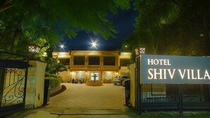 A hotel entrance with a sign reading "HOTEL SHIV VILLA," a gated driveway, and a fountain in the center. - Hotel Shiv Villa by SAH (Abu Road)