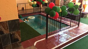 A swimming pool with a tiled deck, surrounded by a metal fence. - Sgegede Guest House (Pretoria)