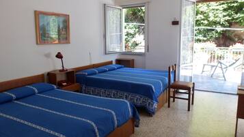 Camera d'albergo con due letti, una finestra, una sedia e una scrivania.