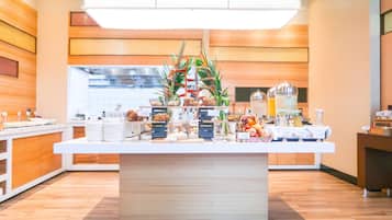 Una cocina moderna con una isla central, paneles de madera y diversos dispensadores de comida y bebida.