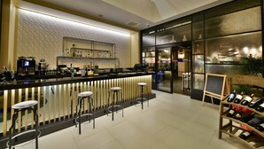 A modern bar area with a counter, stools, and a wine rack. - Park Inn By Radisson Istanbul Ataturk Airport (Istanbul)