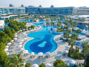 A large hotel with multiple swimming pools, sun loungers, and palm trees. - Sueno Hotels Deluxe Belek - All Inclusive (Serik)