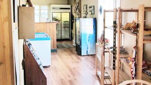 A kitchen with wooden cabinets, a refrigerator, and a wooden bench.