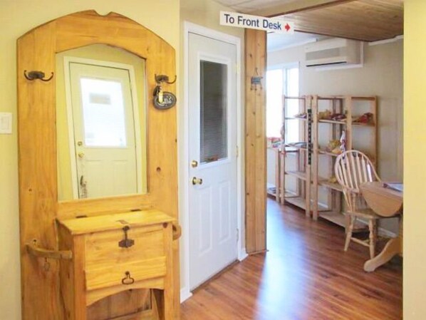 A wooden door with a mirror and a small drawer, leading to a room with a wooden desk, chair, and shelves. - Muskey's Landing Resort (Tay)