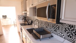 A modern kitchen with a stainless steel sink, a built-in oven, and a microwave. - Duo Housing Hostel (Washington)