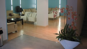 A modern living room with a sofa, coffee table, and a potted plant. - Evenia President Hotel (Salou)