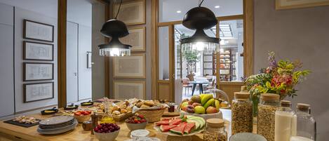 A breakfast buffet with various fruits, pastries, and dairy products.
