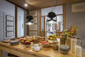 A breakfast buffet with various fruits, pastries, and dairy products. - Margot House (Barcelona)