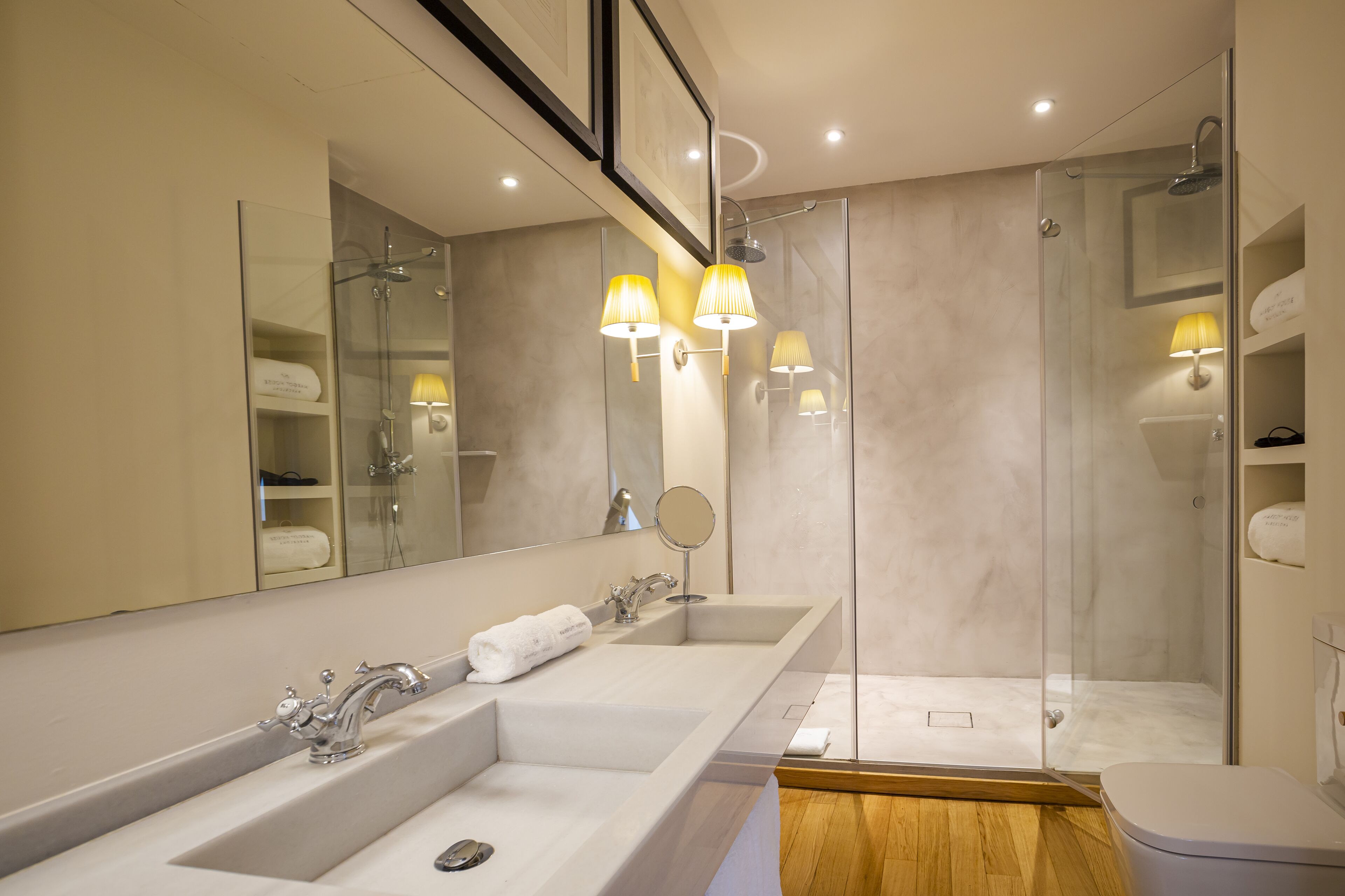 A modern bathroom with a large vanity, a shower, and a toilet.