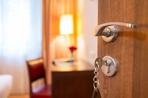 Puerta de habitación de hotel con un ojo de cerradura y un llavero.