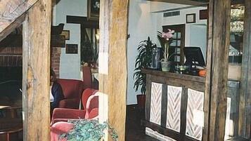 Una sala de estar acogedora con un sillón rojo, una mesa de centro de madera y una chimenea de ladrillo.