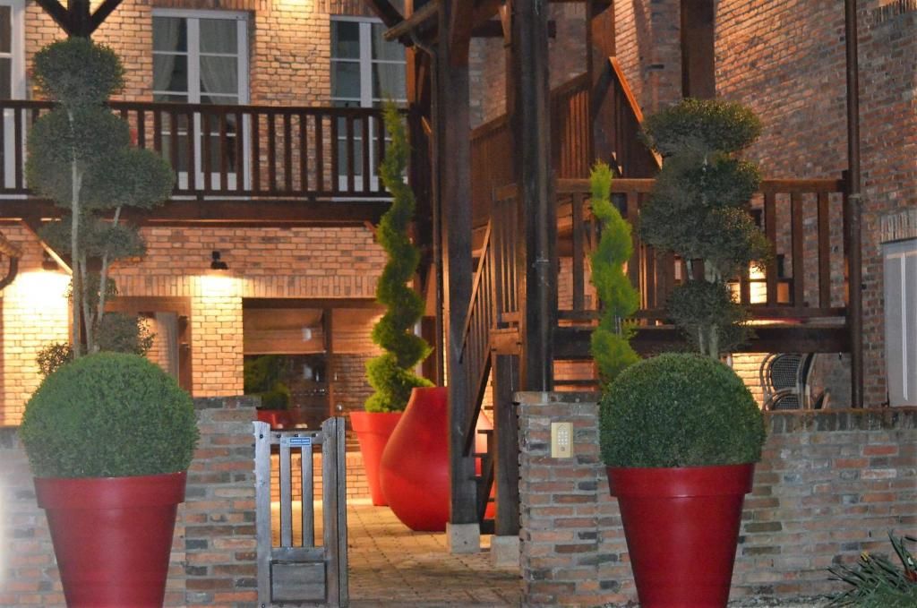 A brick building with a wooden balcony and red potted plants.