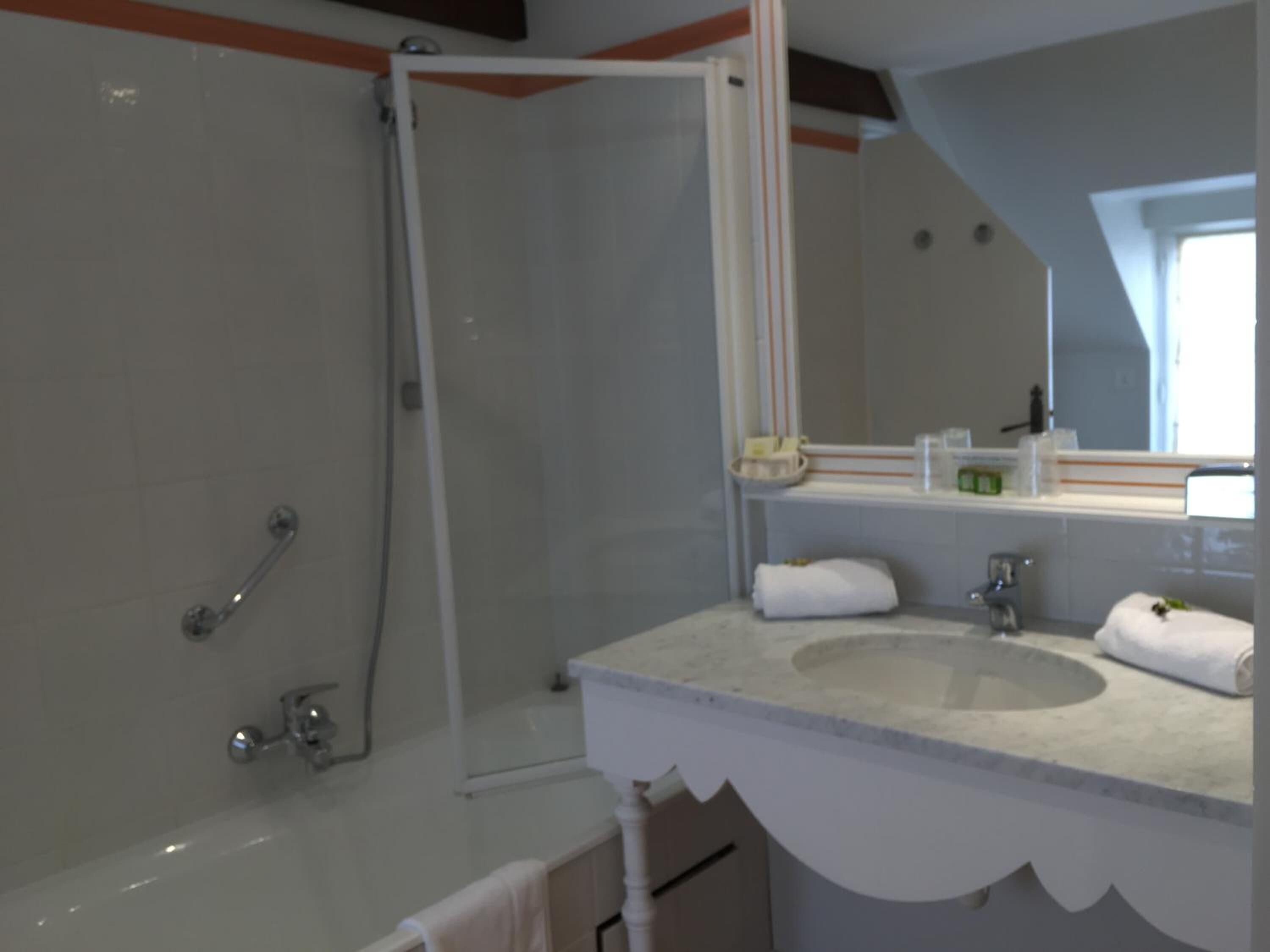Une salle de bain moderne avec une baignoire, une douche, un lavabo et un miroir.