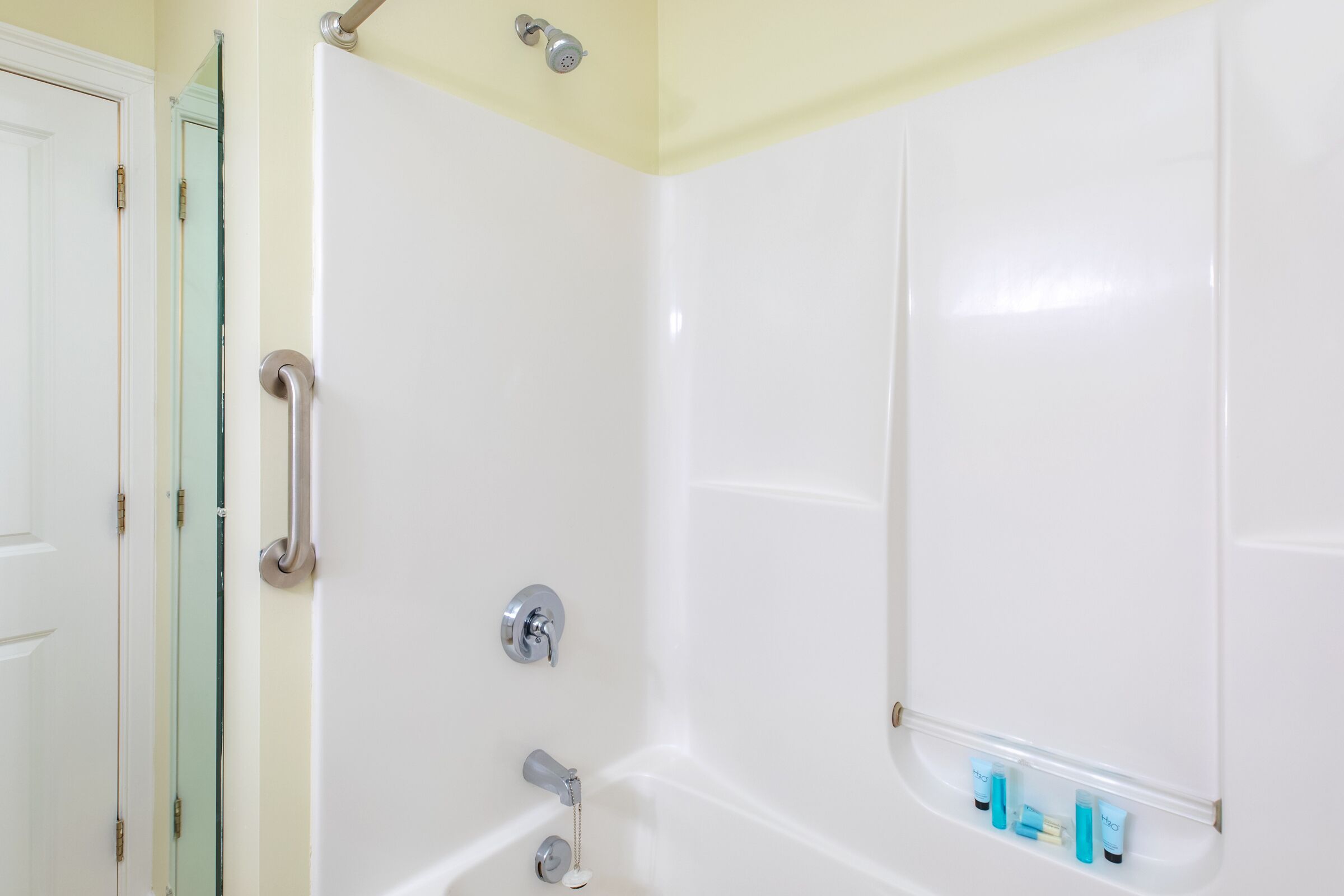 Une salle de bain avec une baignoire, une douche et une porte en verre.