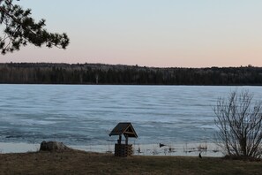 A lakeside view with a wooden structure near the water's edge.