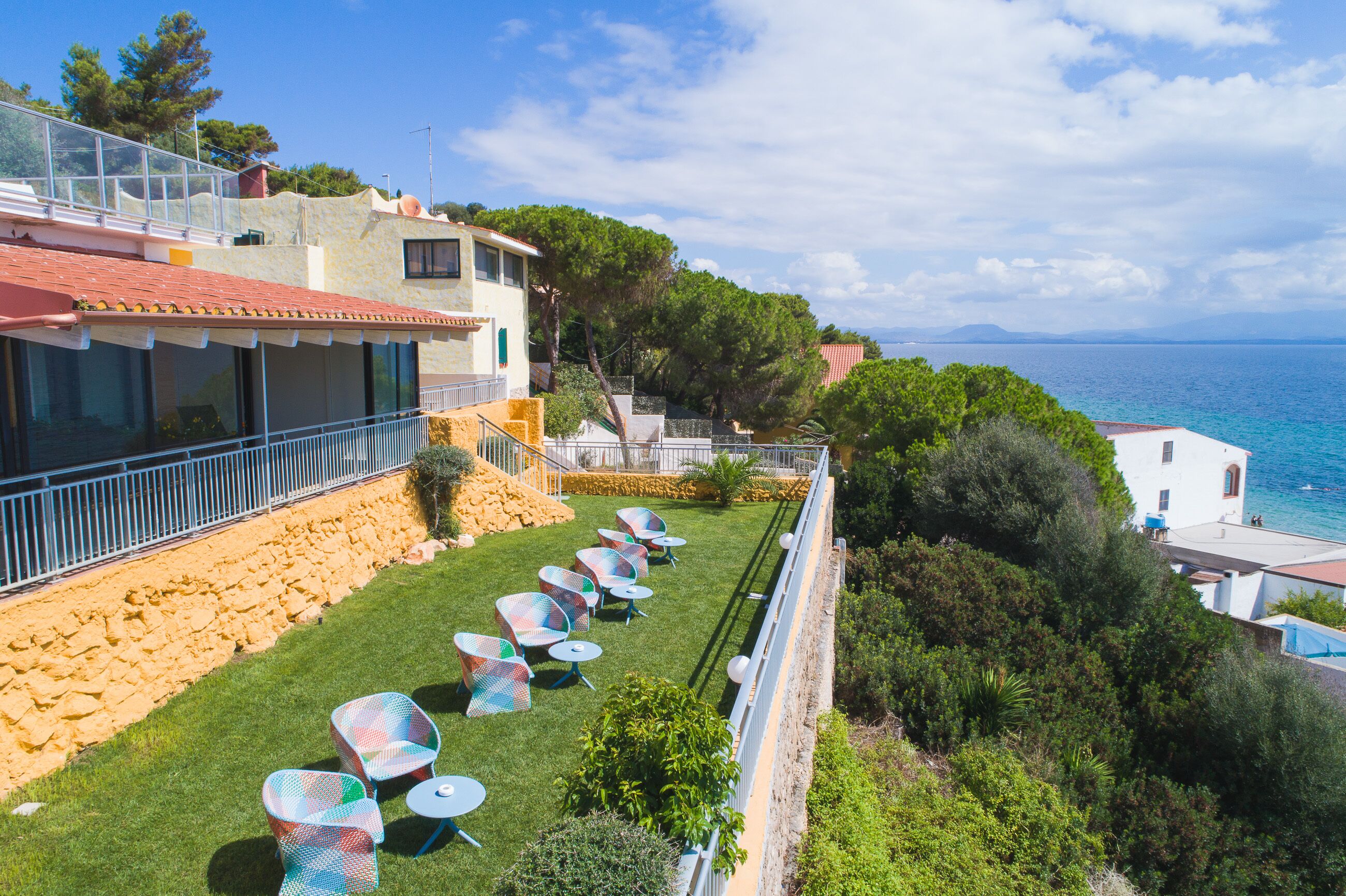 A coastal property with a terrace, outdoor seating, and a view of the sea.