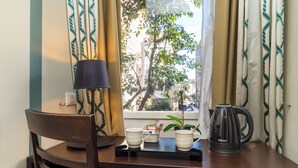 A wooden table with a black lamp, two white mugs, a small plant, and a black kettle. - Chic & Town Luxury Rooms Piazza del popolo (Rome)